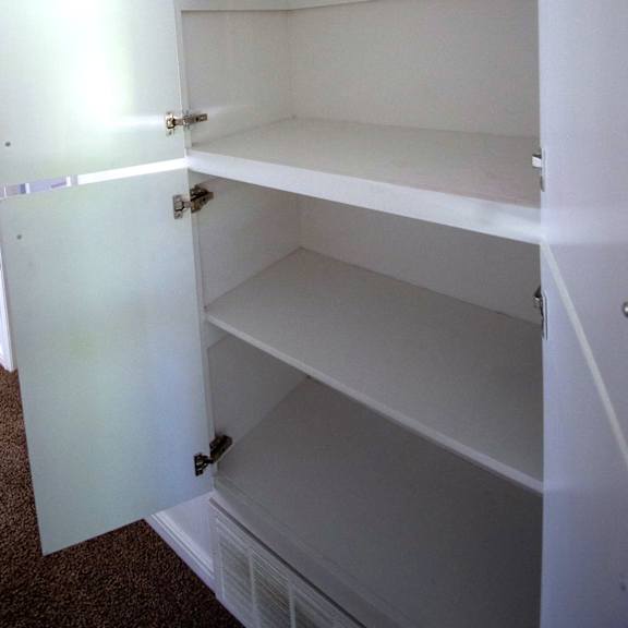 a white open closet with shelves.