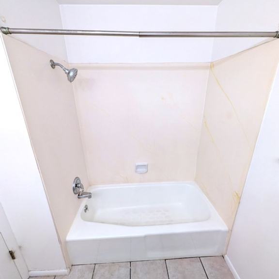 a white bathroom with a tub and shower.