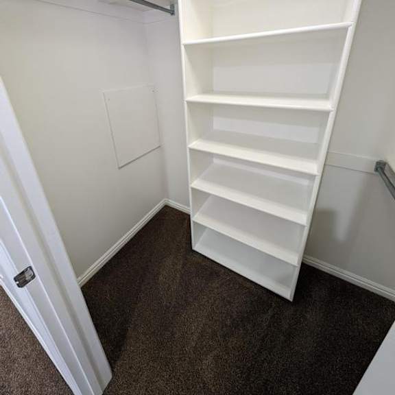 a white shelving unit in a room with white walls.