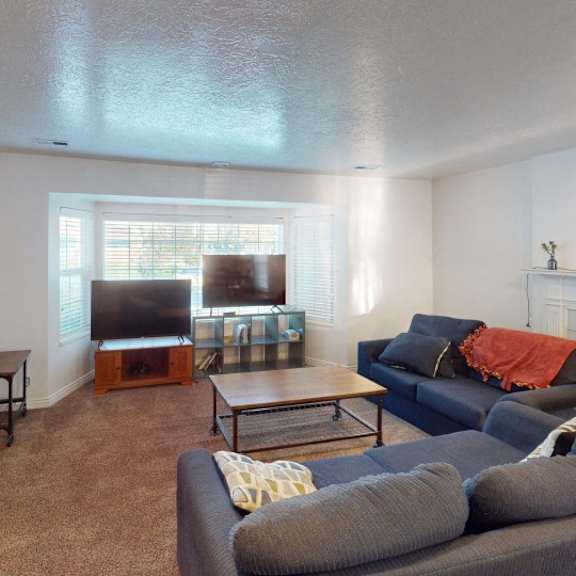 a living room with a grey couch and a fireplace.