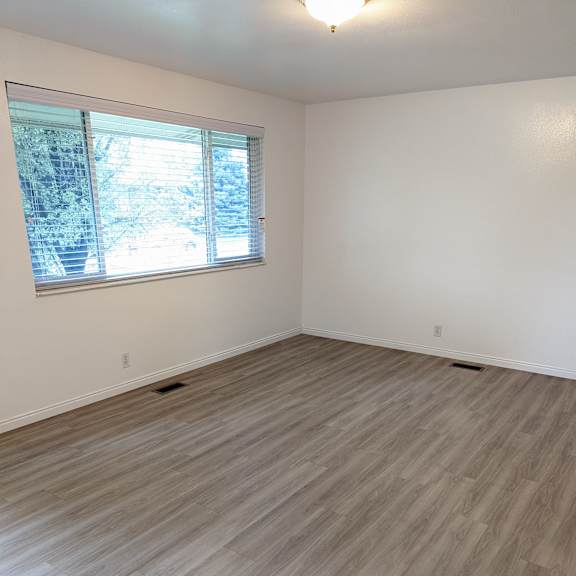 a room with a window and wooden flooring.