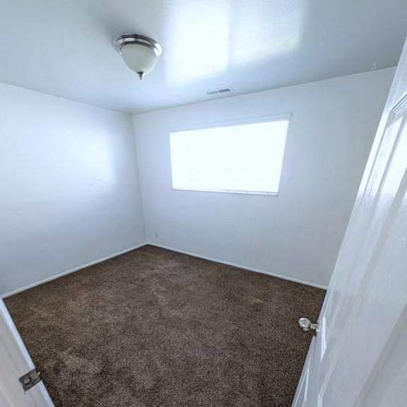 a room with a carpeted floor and a window.