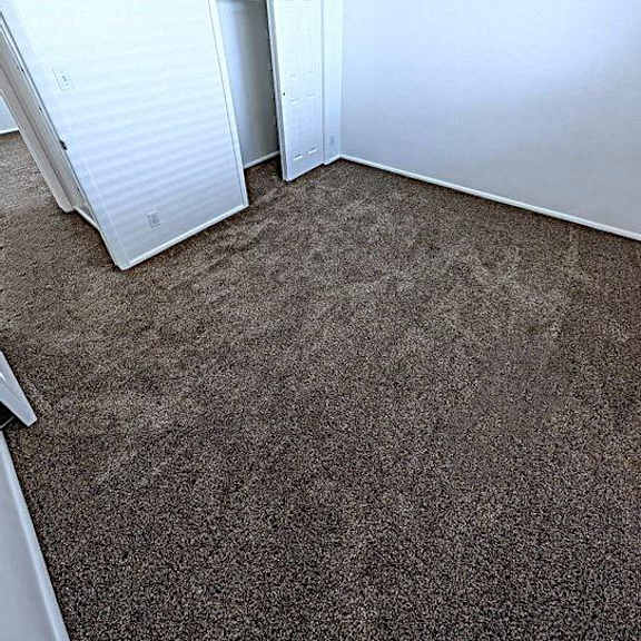 a room with a carpeted floor and a white wall.