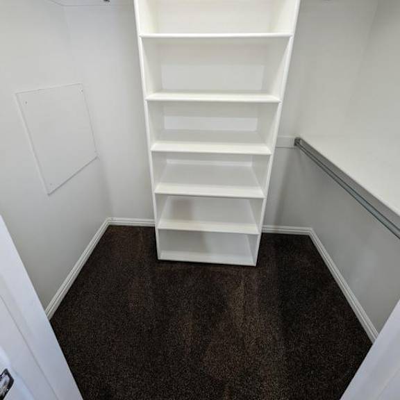 a white shelving unit in a small room.