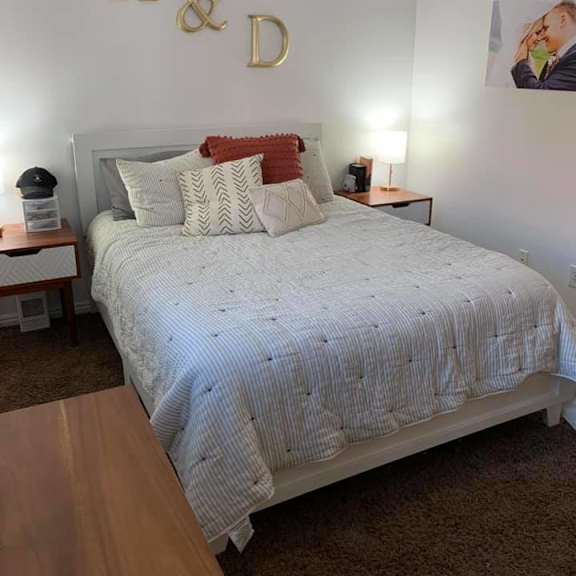 a bedroom with a bed, nightstands, and a ceiling fan.