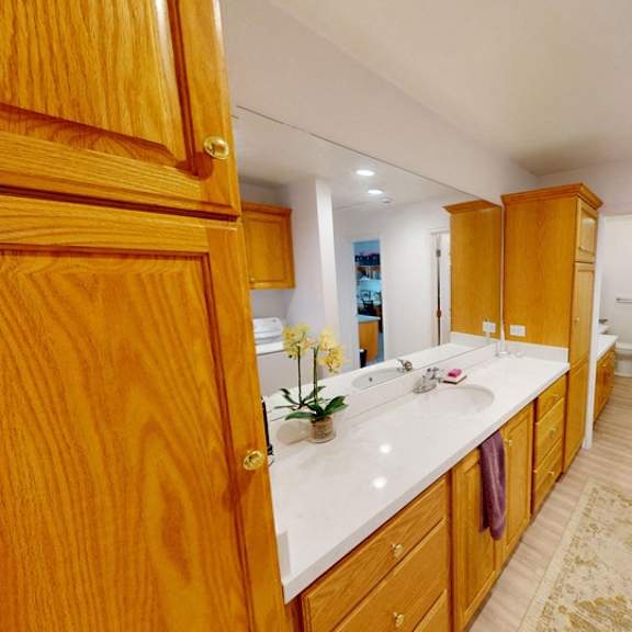 a bathroom with wooden cabinets and a white countertop.