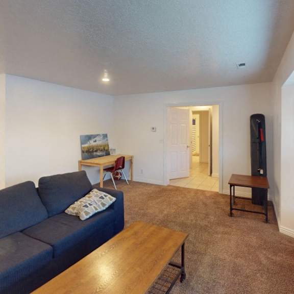 a living room with a blue couch and a wooden coffee table.