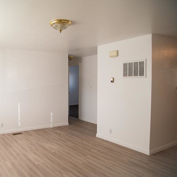 a room with a light brown floor and white walls.