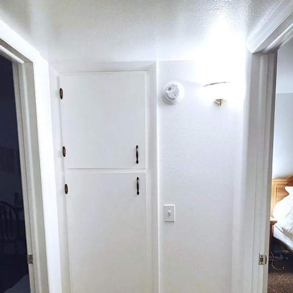 a white door with a light switch on the wall.