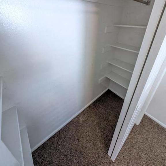 a white refrigerator with a metal handle and a white carpeted floor.