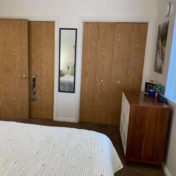 a bedroom with a bed, wardrobe, and a dresser.