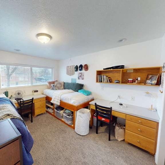 a bedroom with two beds and a desk.