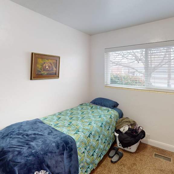 a bedroom with a bed, dresser, and window.