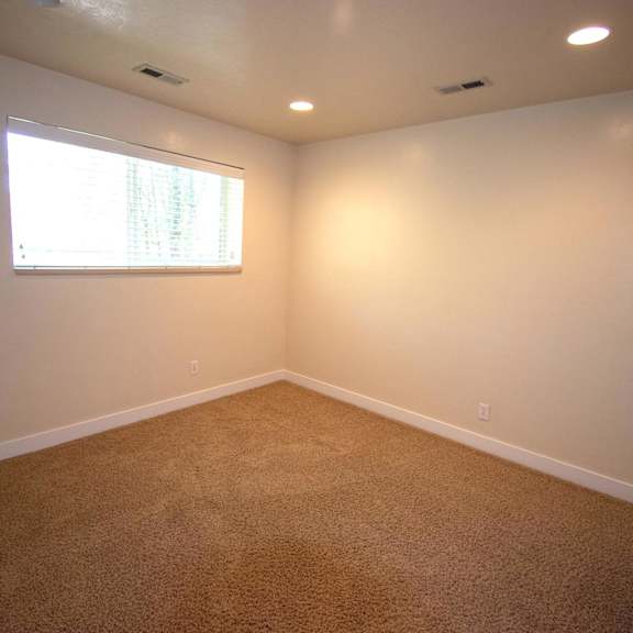 a room with a carpeted floor and a window.