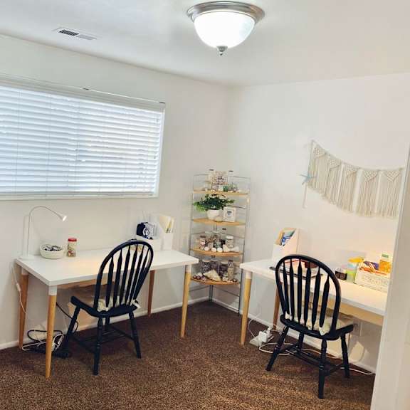 a room with a desk, chair, and a cabinet.