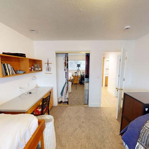 a bedroom with two beds and a desk.