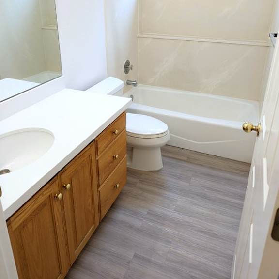 a white bathroom with a toilet, sink, and bathtub.