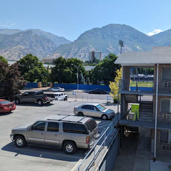 a parking lot with cars and a mountain in the background.