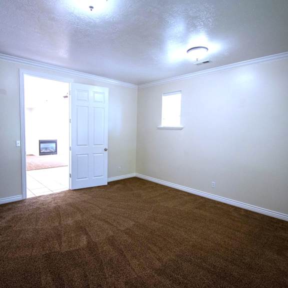 a room with brown carpet and white walls.