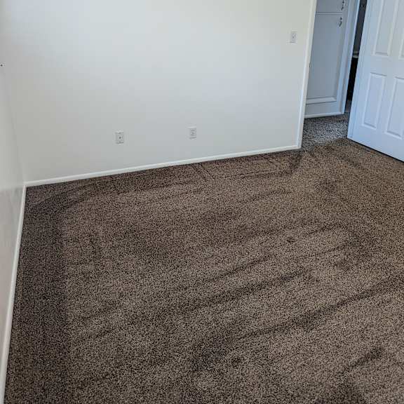 a room with a carpeted floor and a white door.