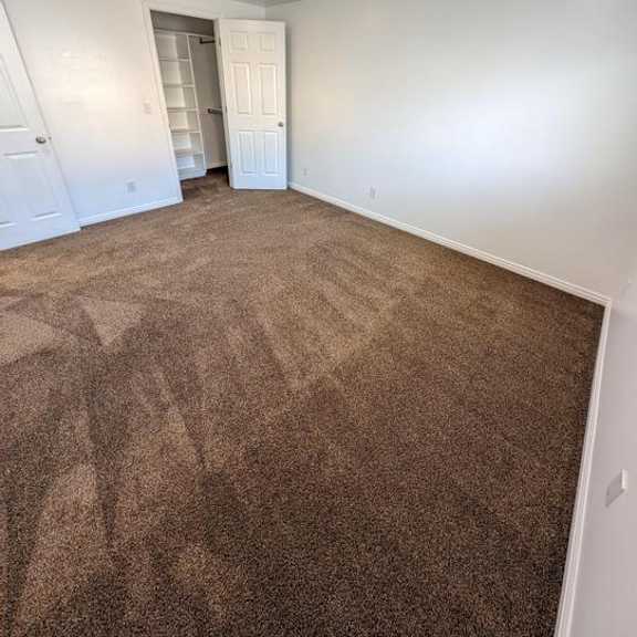 a room with a carpeted floor and a doorway leading to another room.