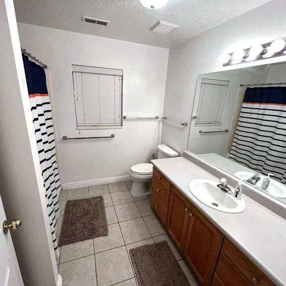 a bathroom with a toilet, sink, and mirror.