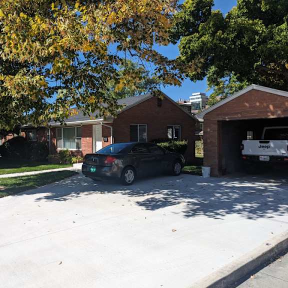 a black car is parked in a driveway.