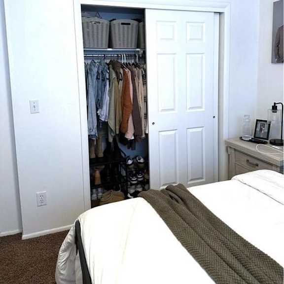 a bedroom with a bed, a wardrobe, and a nightstand.