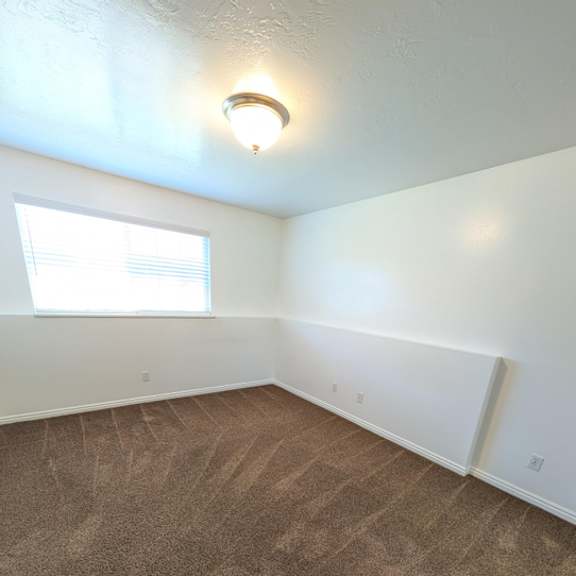 a room with a carpeted floor and a window.