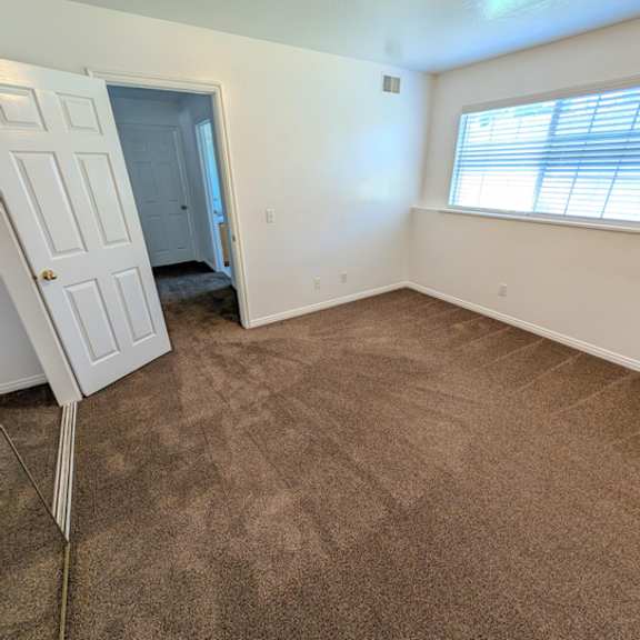 a room with brown carpet and a white door.