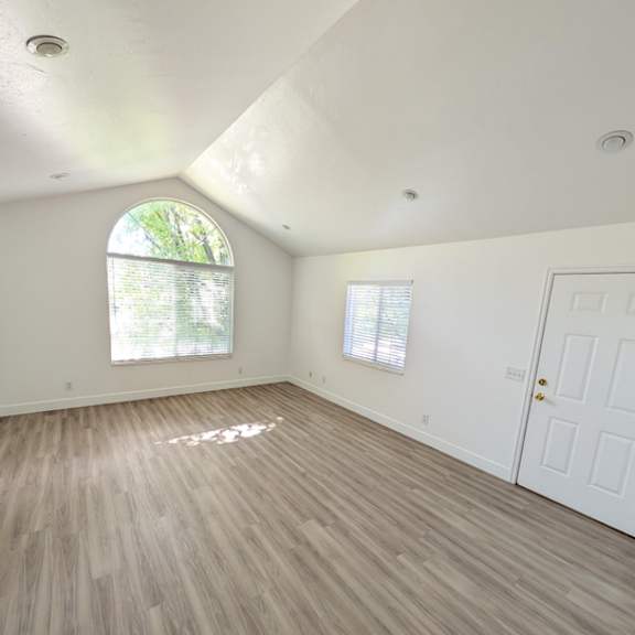 a room with a white door and a window with blinds.
