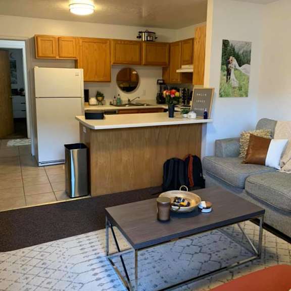 a kitchen with a white refrigerator and wooden cabinets.