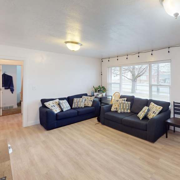 a living room with a black couch and a wooden table.