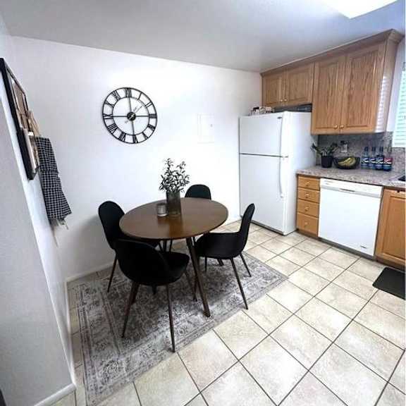 a kitchen with a table and chairs and a clock on the wall.