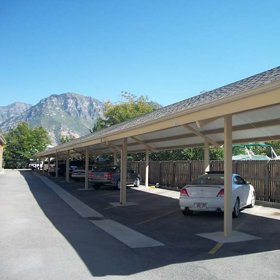 a long covered parking lot with cars parked in it.