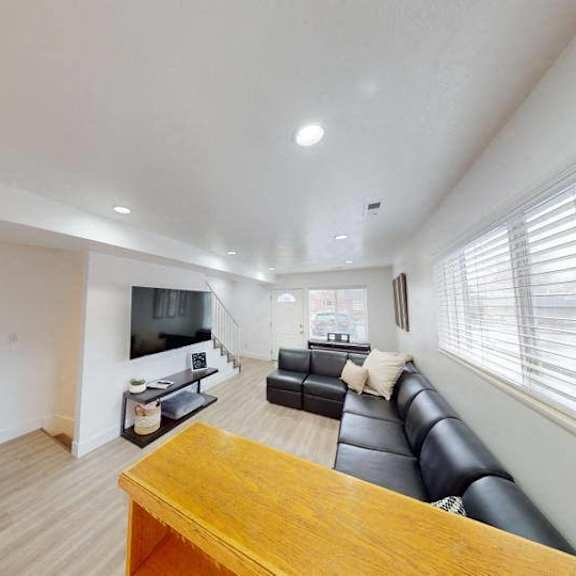 a living room with a couch, a television, and a wooden table.