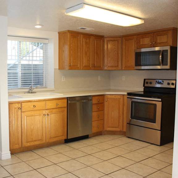 a kitchen with wooden cabinets and a white door.