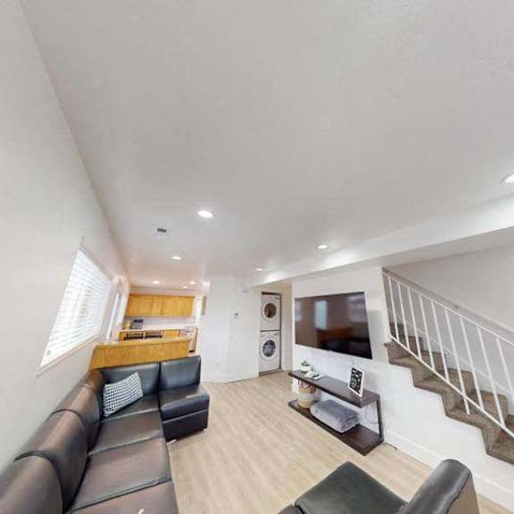 a living room with a staircase leading to the upper floor.