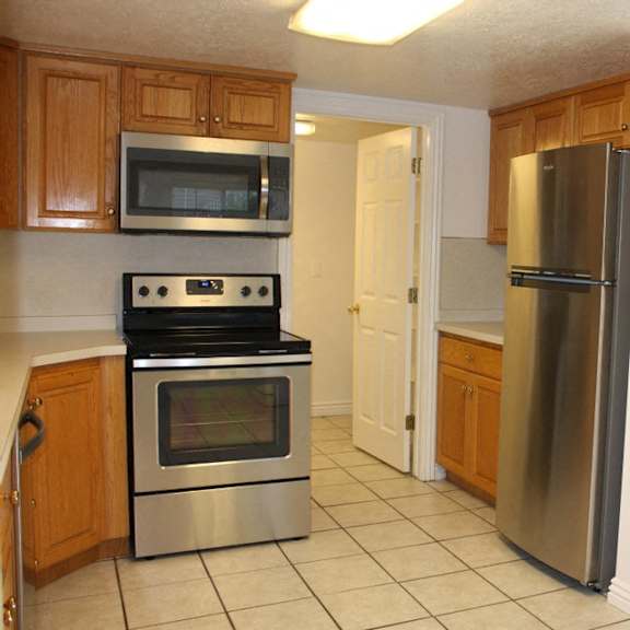 a kitchen with a stove, microwave, and refrigerator.