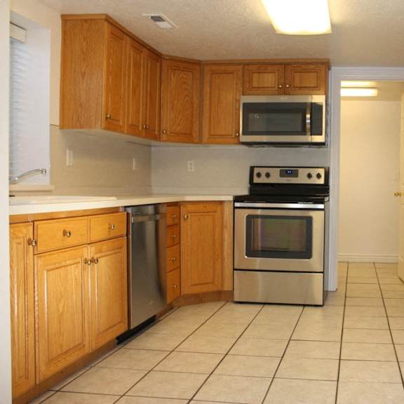 a kitchen with wooden cabinets and a stainless steel oven.