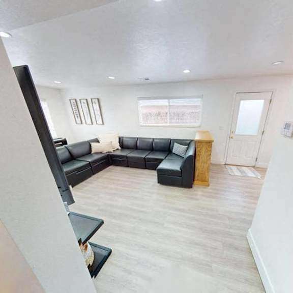 a living room with a black couch and a wooden coffee table.