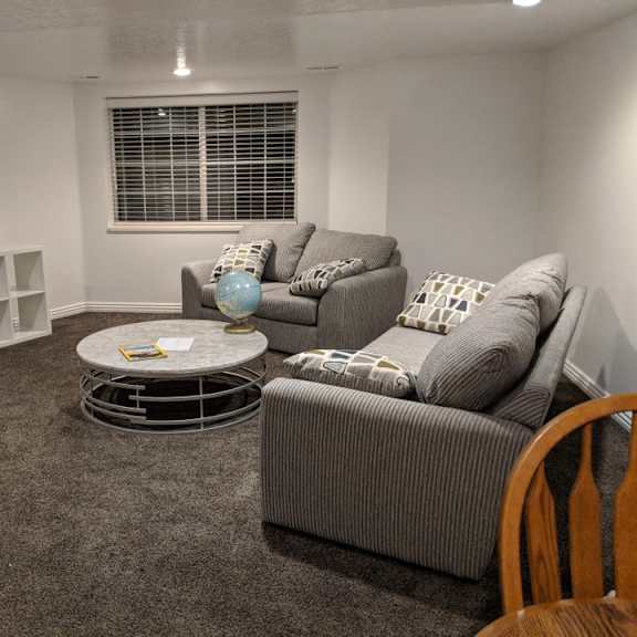 a living room with a grey couch, a white coffee table, and a grey rug.
