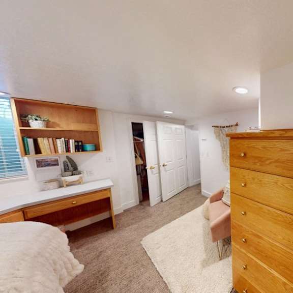 a long wooden chest of drawers is in a room with white walls.
