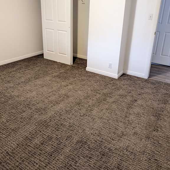 a room with a carpeted floor and a white door.