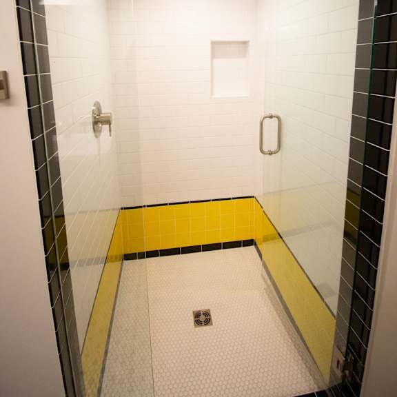 a bathroom with a yellow stripe on the floor.