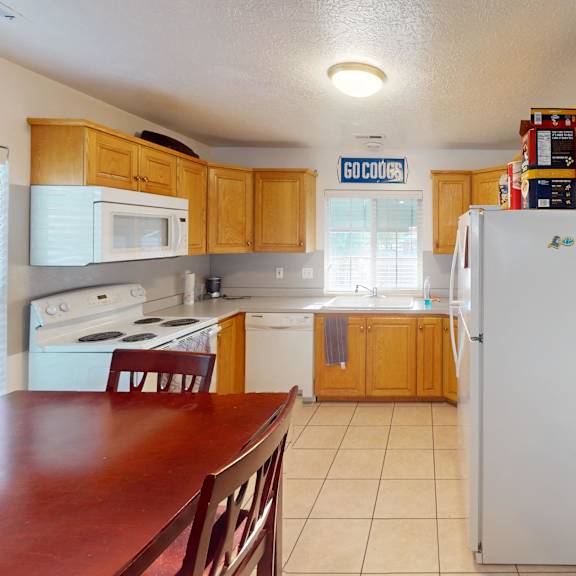 a kitchen with a white refrigerator and wooden cabinets.