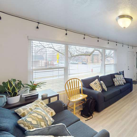 a living room with a blue couch and a yellow chair.