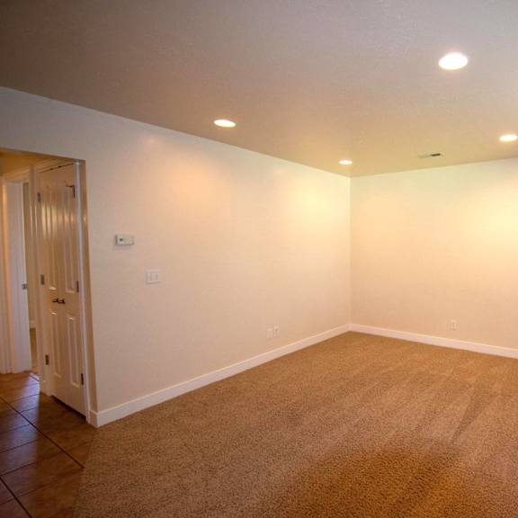 a room with a carpeted floor and a door on the left.