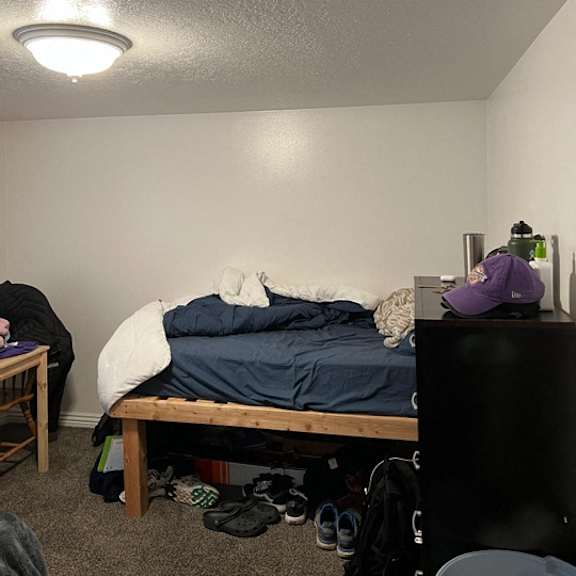 a bedroom with a bed, a desk, and a chair.
