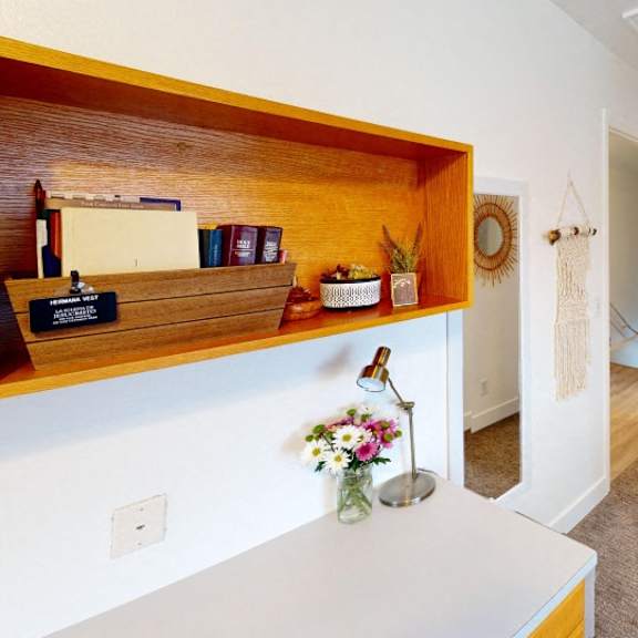 a small room with a wooden shelf and a white door.